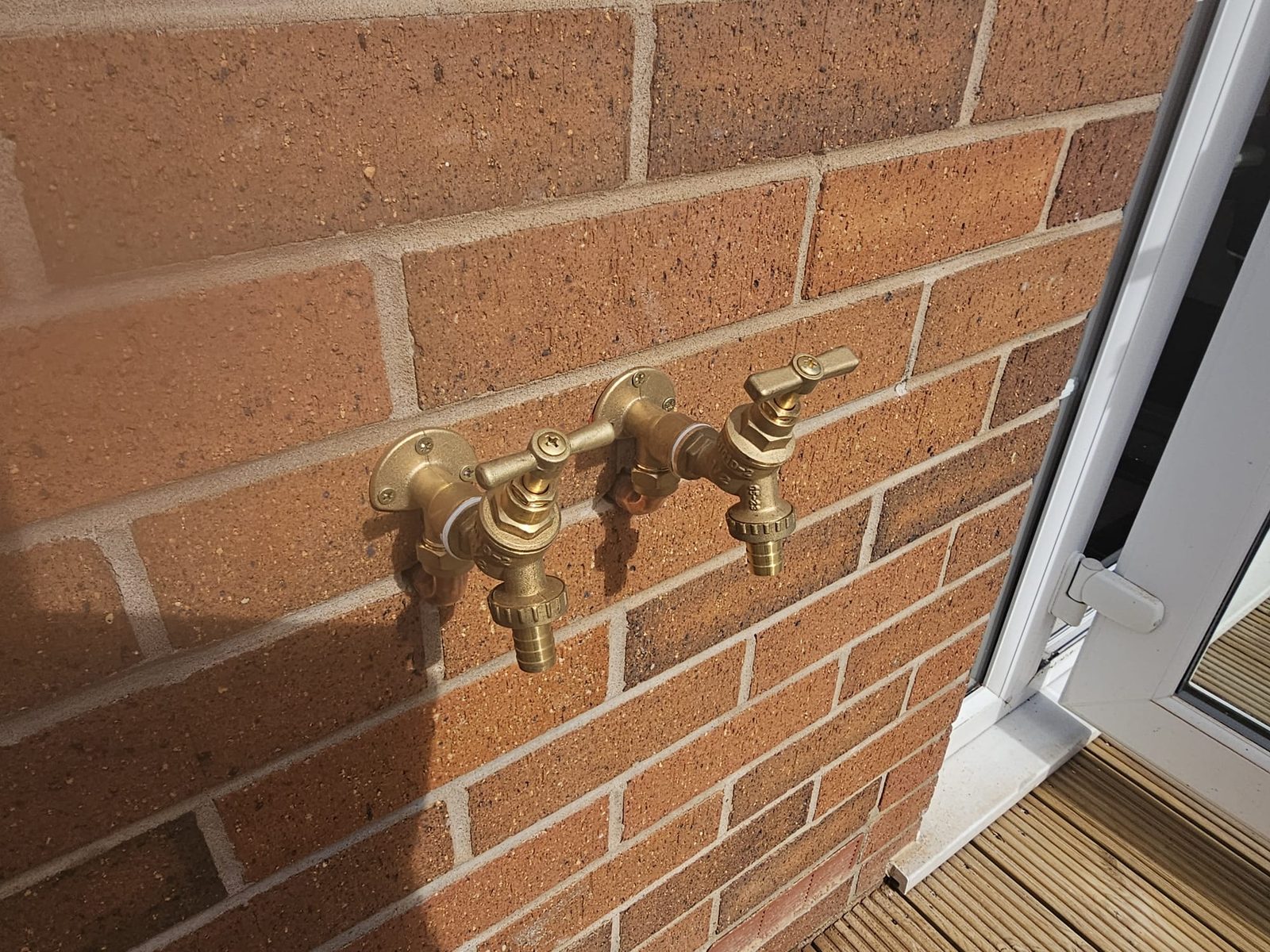 Two outdoor brass garden taps